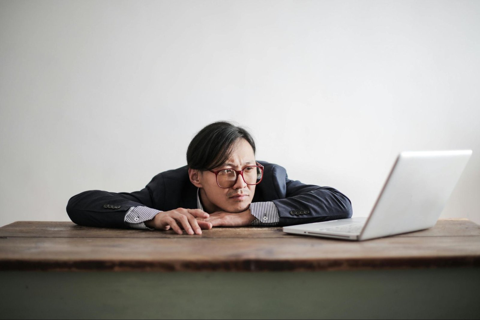 A frustrated man in business attire staring at his laptop